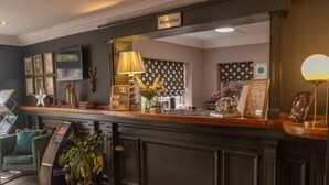 A reception area with a dark wood reception desk, framed pictures, a television, and a sign labeled "Reception". - Brackenborough Hotel, BW Signature Collection (Louth)