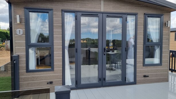 A modern building with large glass doors and windows, a wooden exterior, and a deck area. - Brackenborough Hotel, BW Signature Collection (Louth)