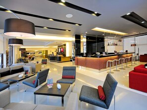 A modern hotel lobby with seating areas, a reception desk, and a bar. - ibis Bangkok Sukhumvit 4 (Bangkok)