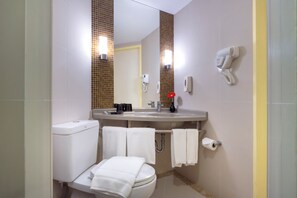 Een badkamer met toilet, wastafel en handdroger.