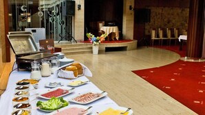 Disposição de buffet com diversos alimentos e utensílios.
