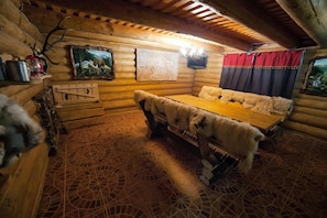 A log cabin room with a wooden bed, a fireplace, and a painting on the wall. - Praha Hotel (Uzhhorod)