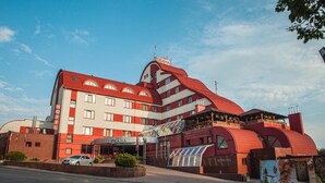 Um edifício de vários andares com um esquema de cores marcante em vermelho e branco, que inclui um restaurante e uma área de boliche.