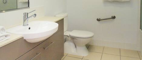 Un baño con un lavabo blanco, un inodoro y una ducha.