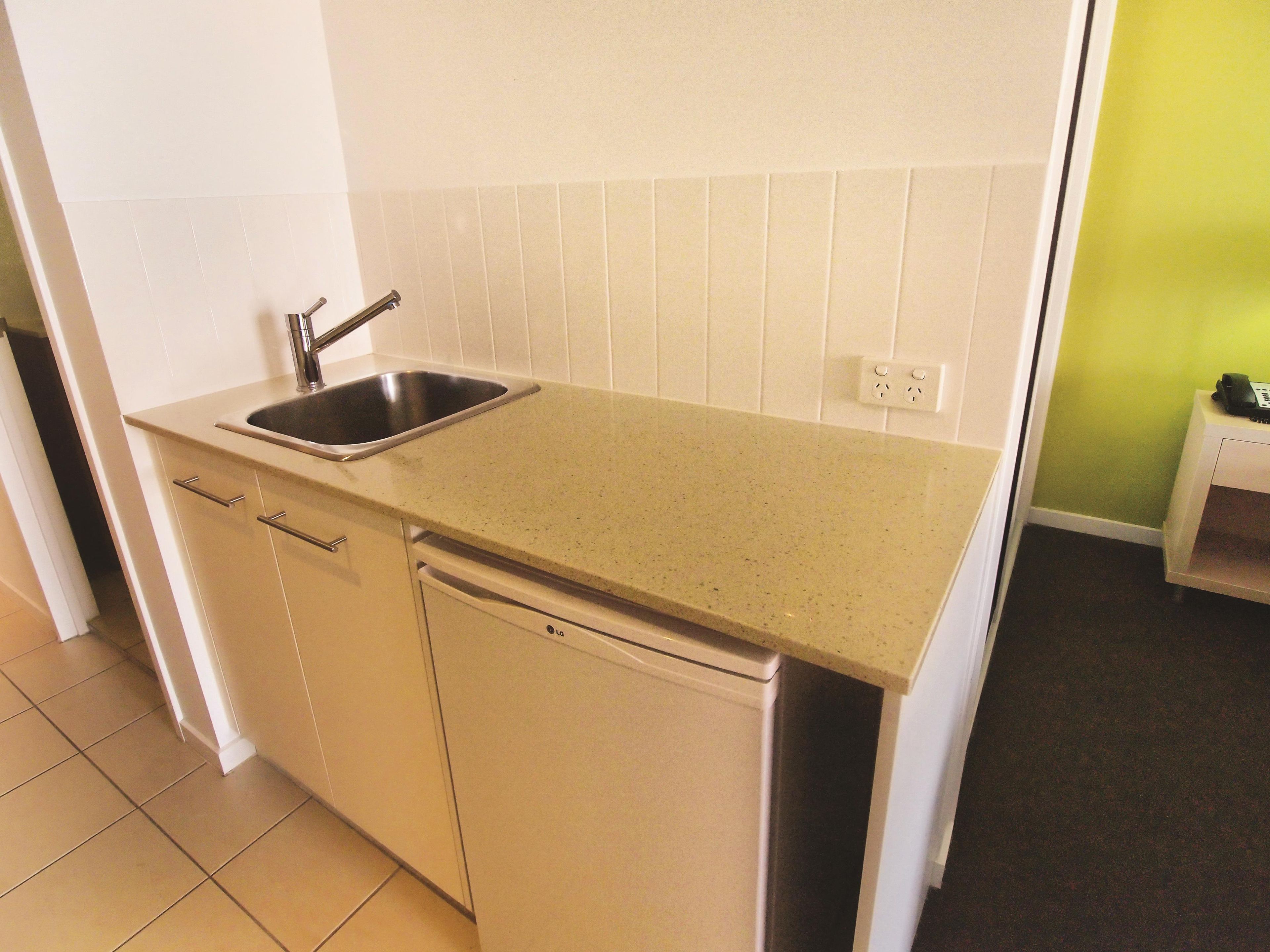 A compact kitchen with a sink, a dishwasher, and a countertop.