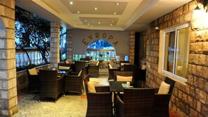 Un restaurante con terraza, paredes de piedra y un letrero que dice "EVROPA".