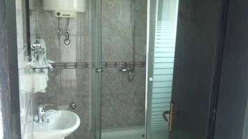Une salle de bain avec une douche à parois de verre, un lavabo et des toilettes.