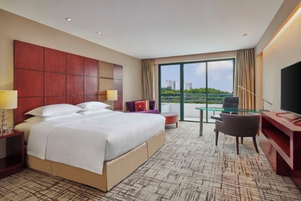 Una habitación de hotel con una cama grande, un escritorio, una silla y un televisor.