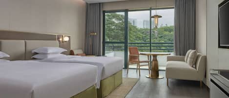 Ein Hotelzimmer mit zwei Betten, einer Couch, einem Esstisch und einem Fernseher.