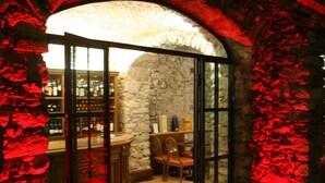 Un interior con un arco de piedra que conduce a una zona de bar.