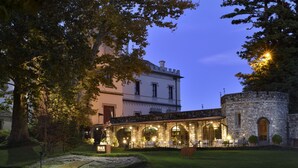A historic building with a stone facade, arched windows, and a courtyard with outdoor seating. - Castello Dal Pozzo Resort Lago Maggiore - Preferred Hotels & Resorts  (Oleggio Castello)