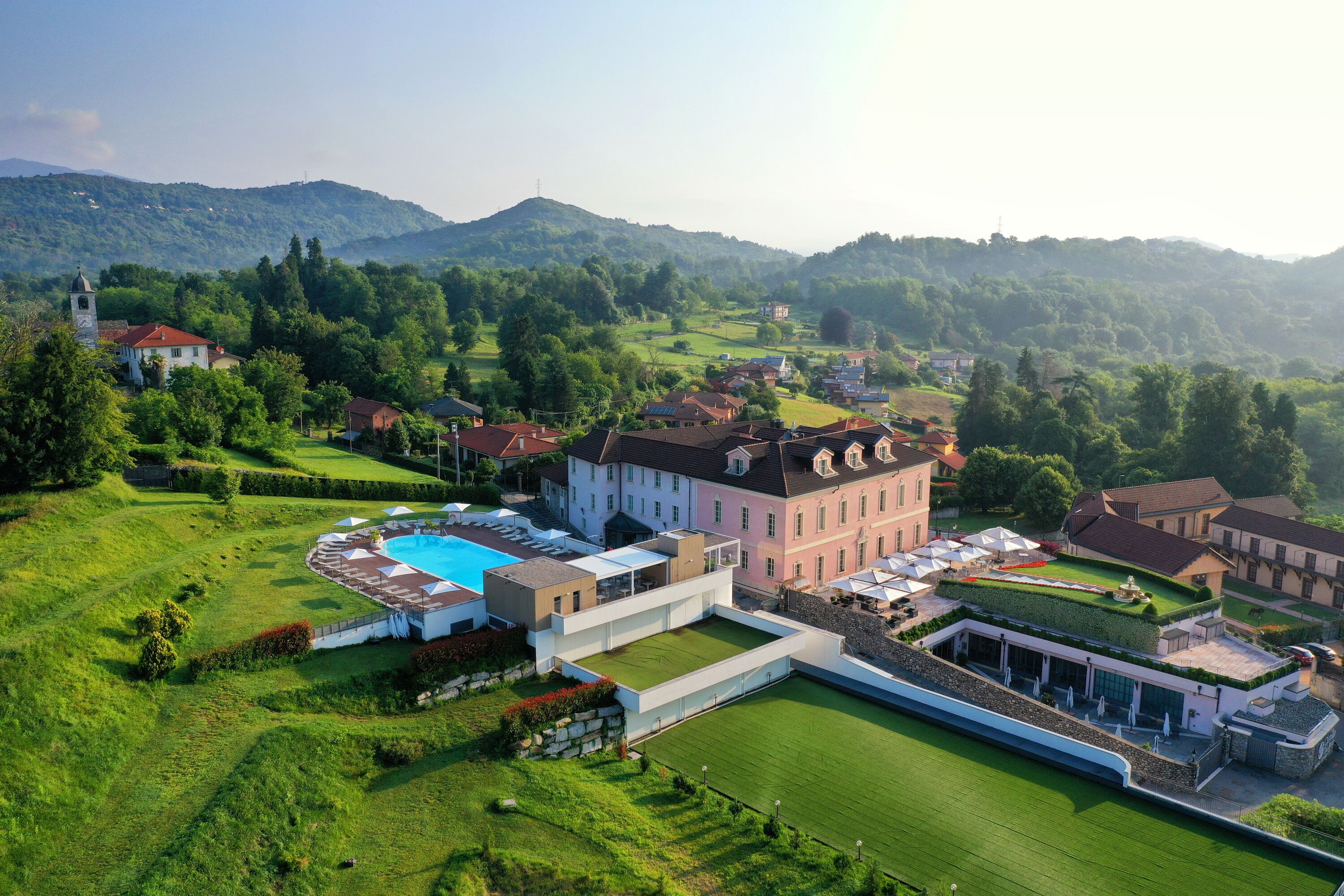 A large estate with a swimming pool, manicured lawns, and multiple buildings.