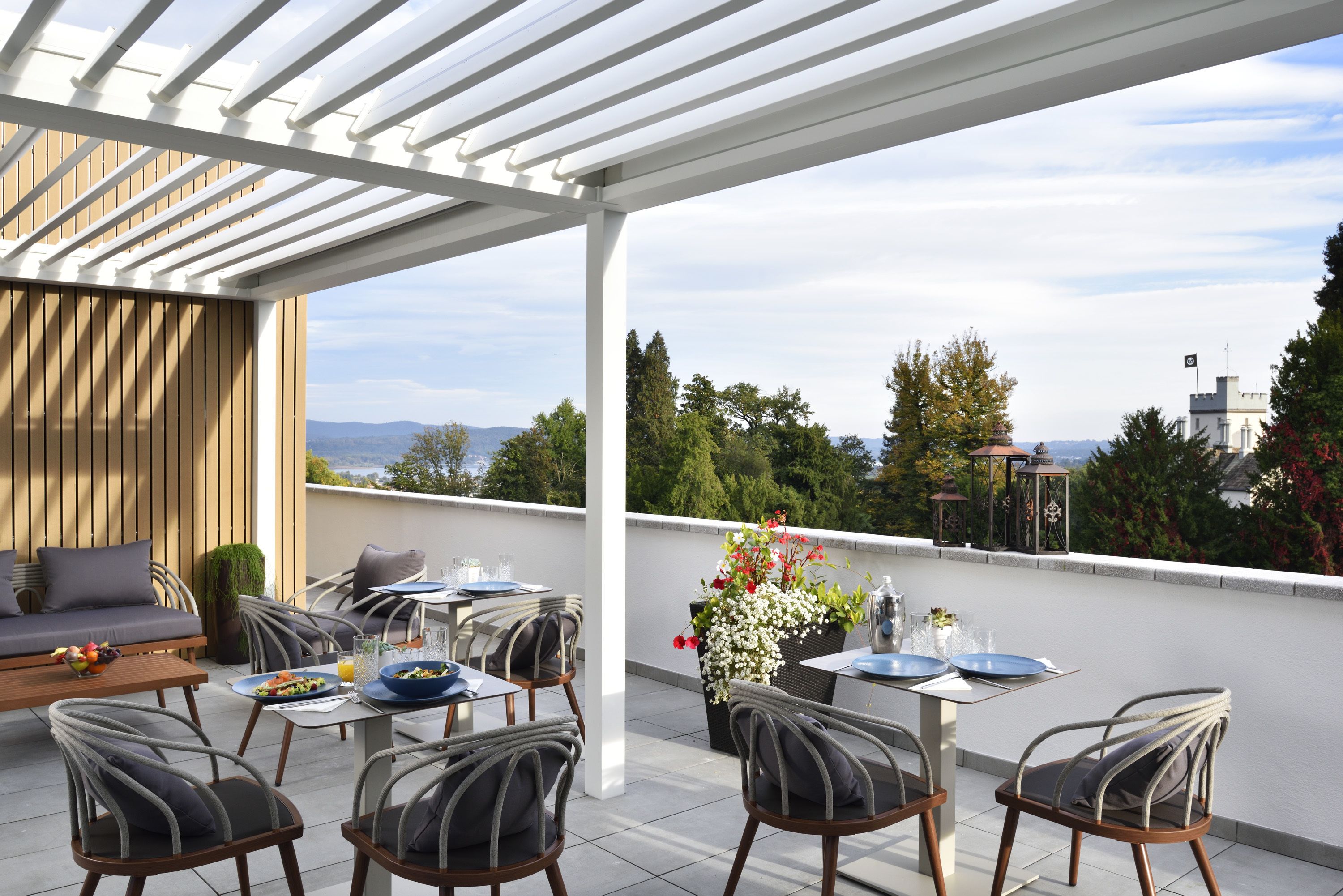 A covered outdoor dining area with a view of the city skyline.