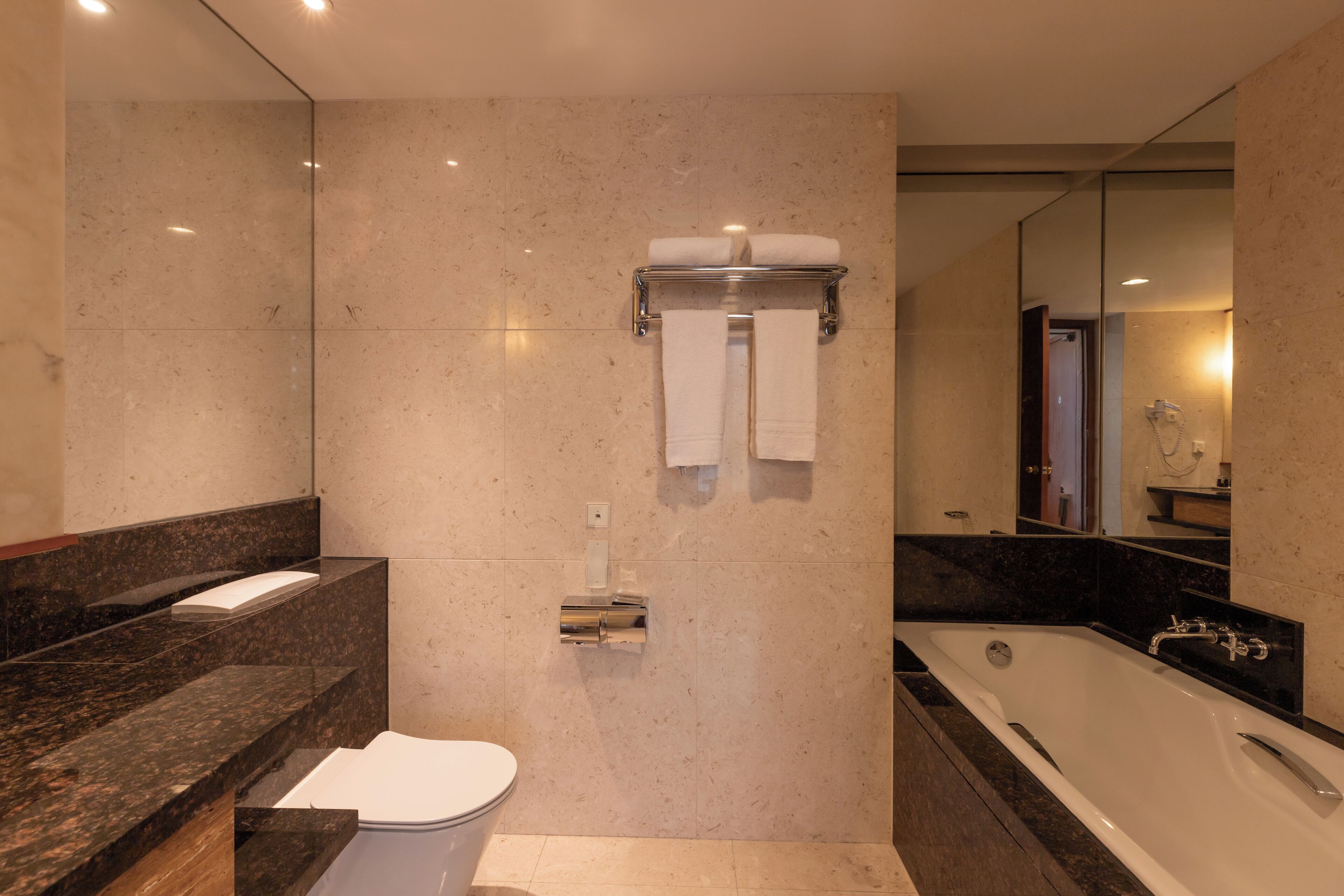 A modern bathroom with a toilet, sink, and bathtub.