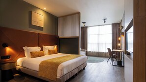 A modern hotel room with a large bed, a desk, and a view of the outdoors. - Shanghai Hotel Holland (Delft)