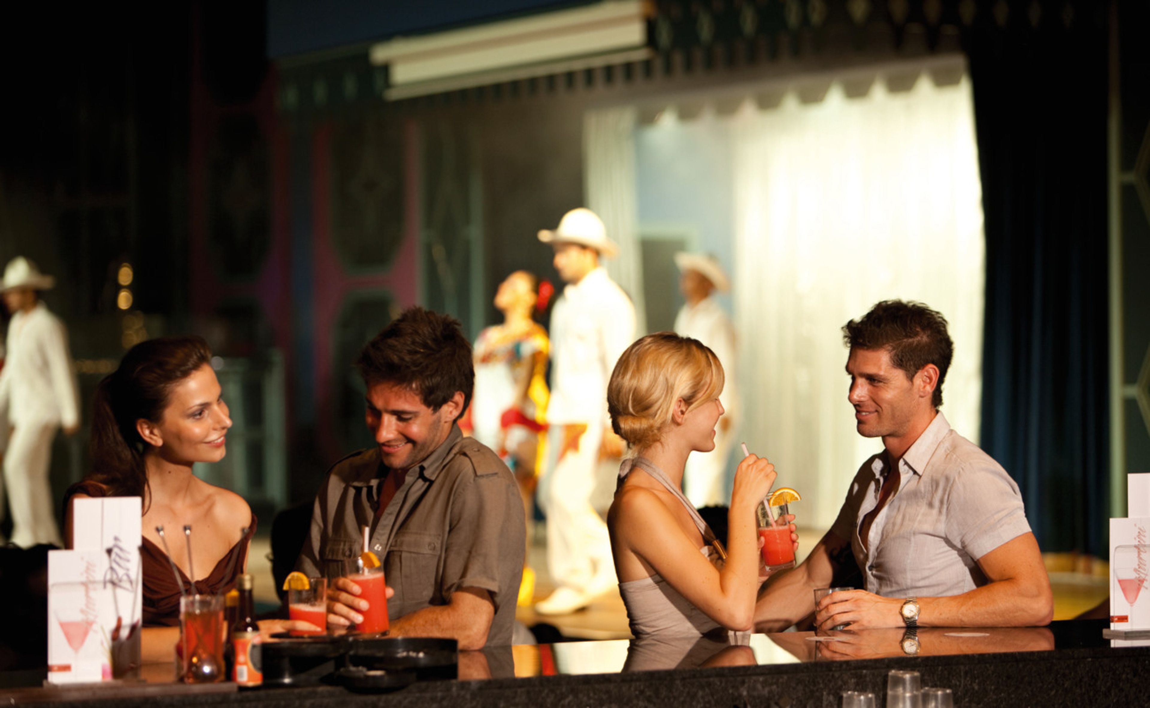A bar area with a counter and several people seated.