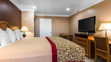 Habitación de hotel con cama, televisión, escritorio y silla.