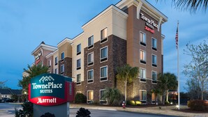 TownePlace Suites, un hôtel Marriott au design moderne, avec de nombreux étages et un drapeau américain bien visible.