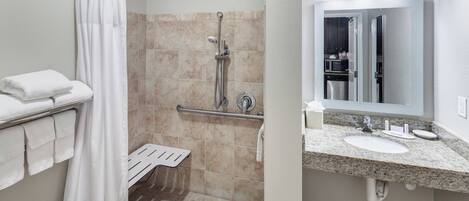 A modern bathroom with a shower, a toilet, and a sink with a mirror.