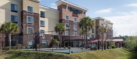 Een TownePlace Suites hotel met een basketbalveld, palmbomen en een heldere lucht.