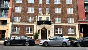 A multi-story brick building with a central entrance, several windows, and a sign for 'The Eldon'. - The Eldon Luxury Suites (Washington)