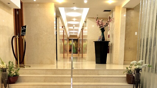 A hotel lobby with a black carpet featuring 'The Eldon Washington DC' logo, marble steps, and a glass door leading to a room. - The Eldon Luxury Suites (Washington)
