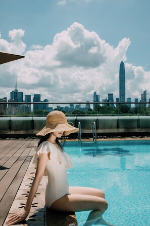 Alberca al aire libre, sombrillas en la alberca y camastros