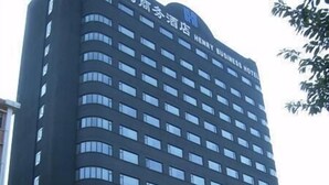 A tall, modern hotel building with a dark facade and numerous windows. - Henry Business Hotel (Guangzhou)