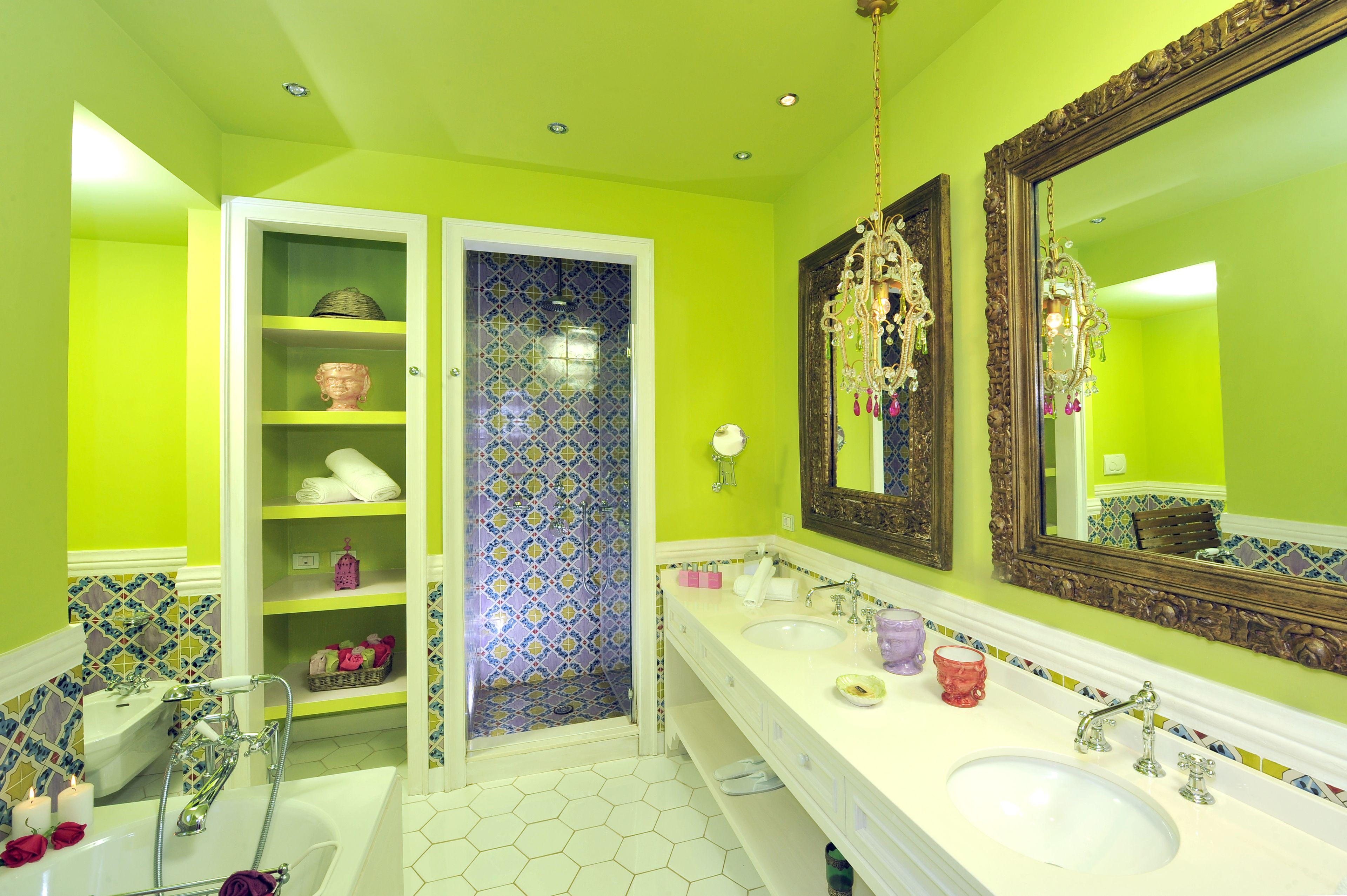 Une salle de bain avec deux lavabos, une douche et un meuble-lavabo avec des étagères.