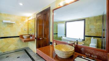 A modern bathroom with a large mirror, a granite countertop, and a large sink.