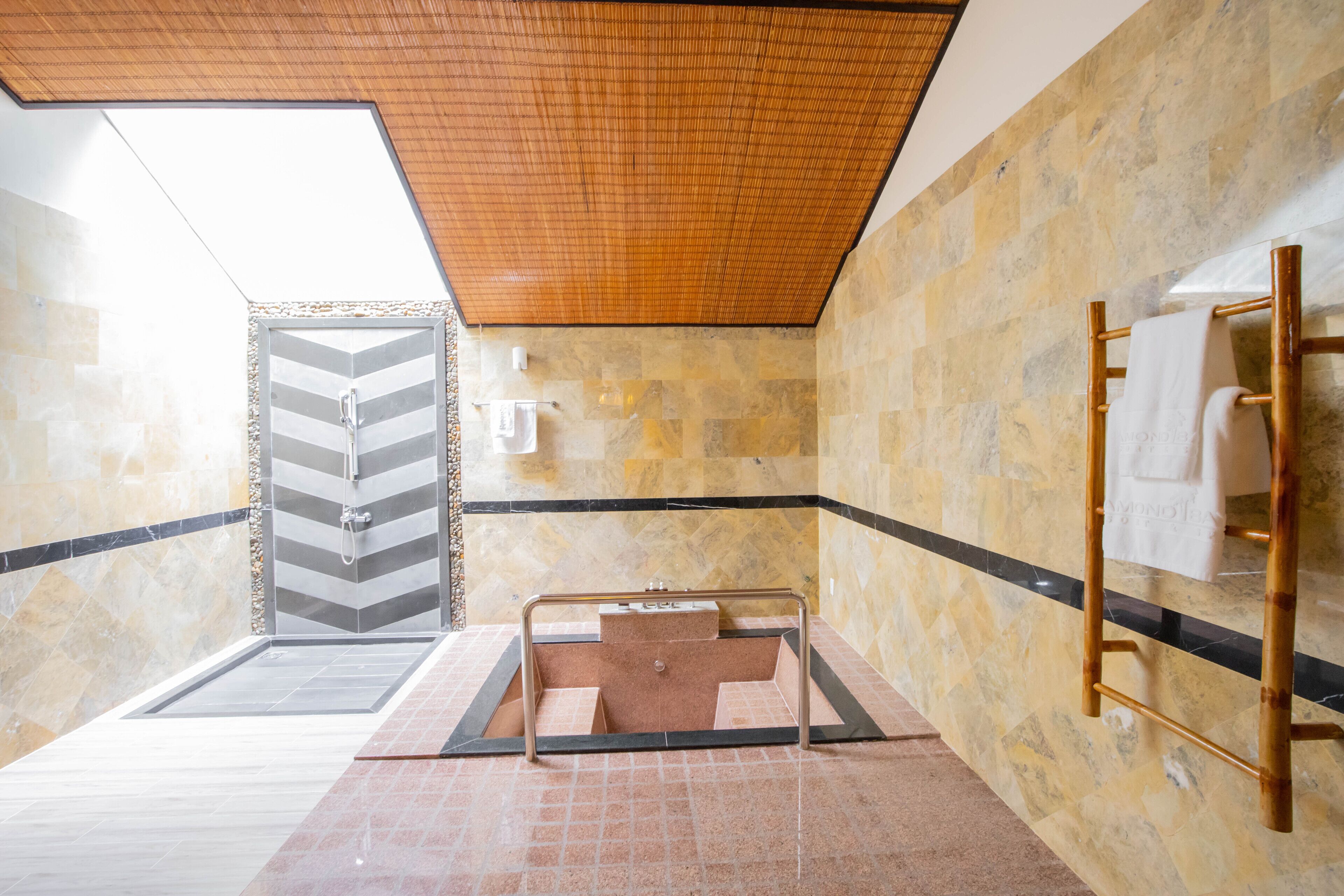 A modern bathroom with a shower, a towel rack, and a view of the outside.