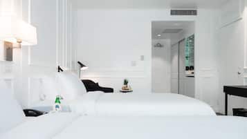 Una habitación de hotel moderna con una cama grande, mesitas de noche, un escritorio y una lámpara.