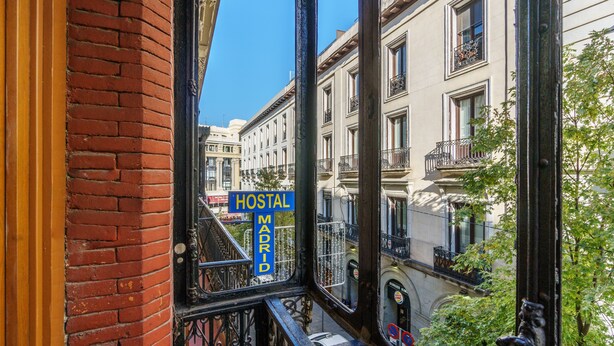 A view through a window of a building with a sign reading "HOSTAL MADRID". - Hostal Madrid (Madrid)