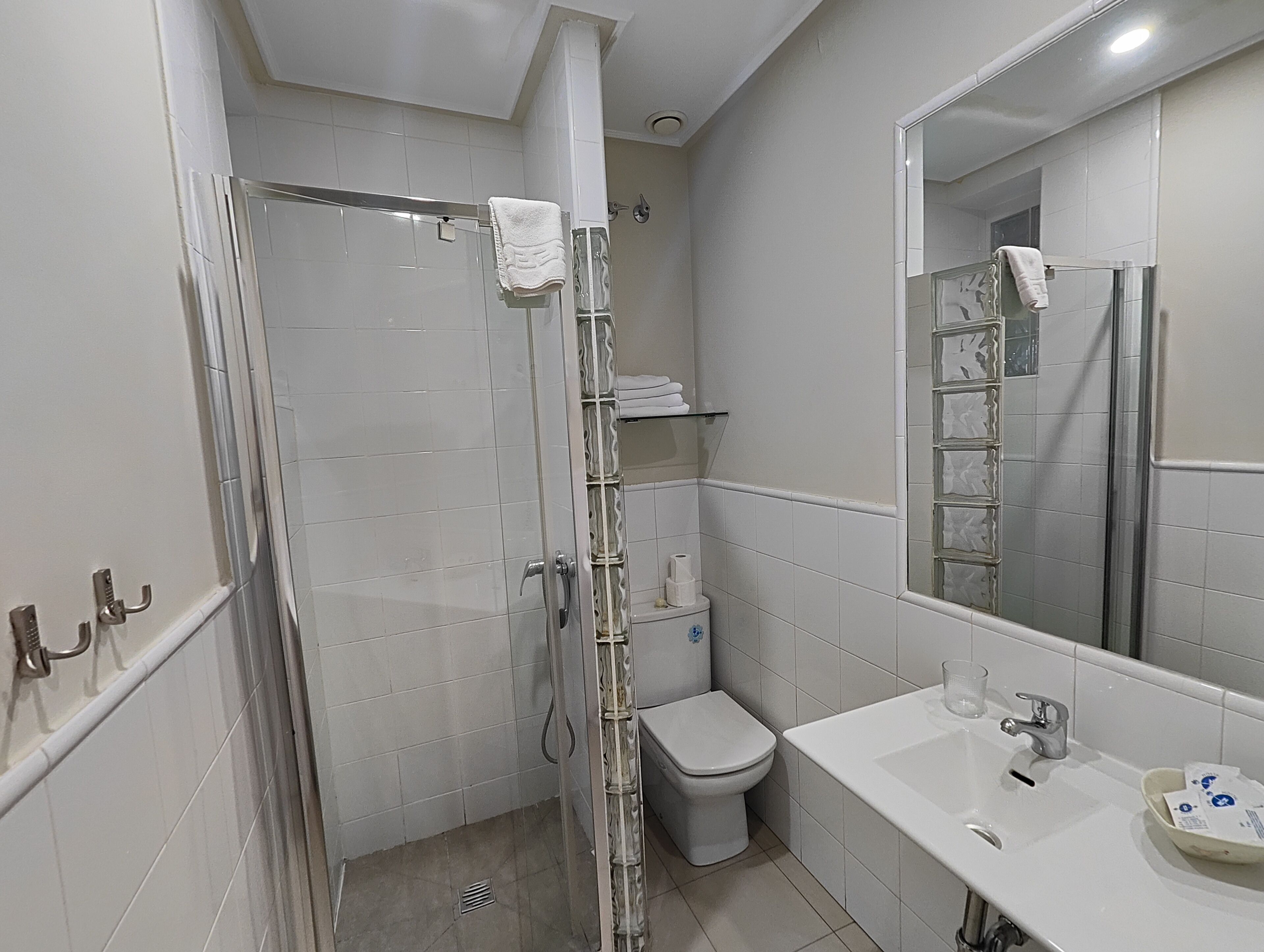 A bathroom with a shower, toilet, and sink.
