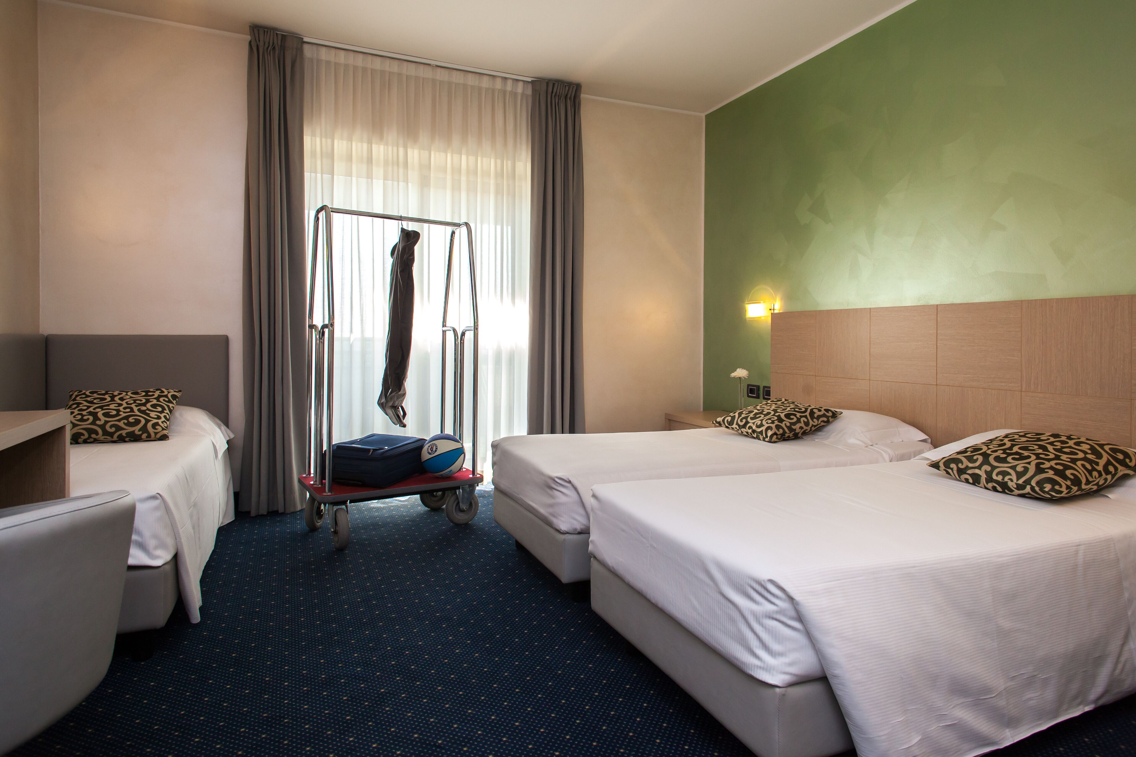 A hotel room with two beds, a desk, and a chair.