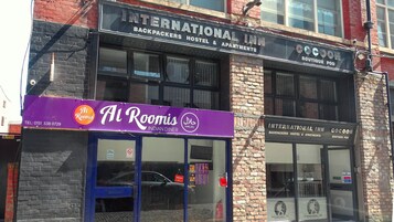 A building with multiple businesses including an international inn, a boutique pod, and Al Roomis Indian diner.