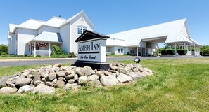 A large white building with a sign reading "Amish Inn Be Our Guest." - Amish Inn (Nappanee)