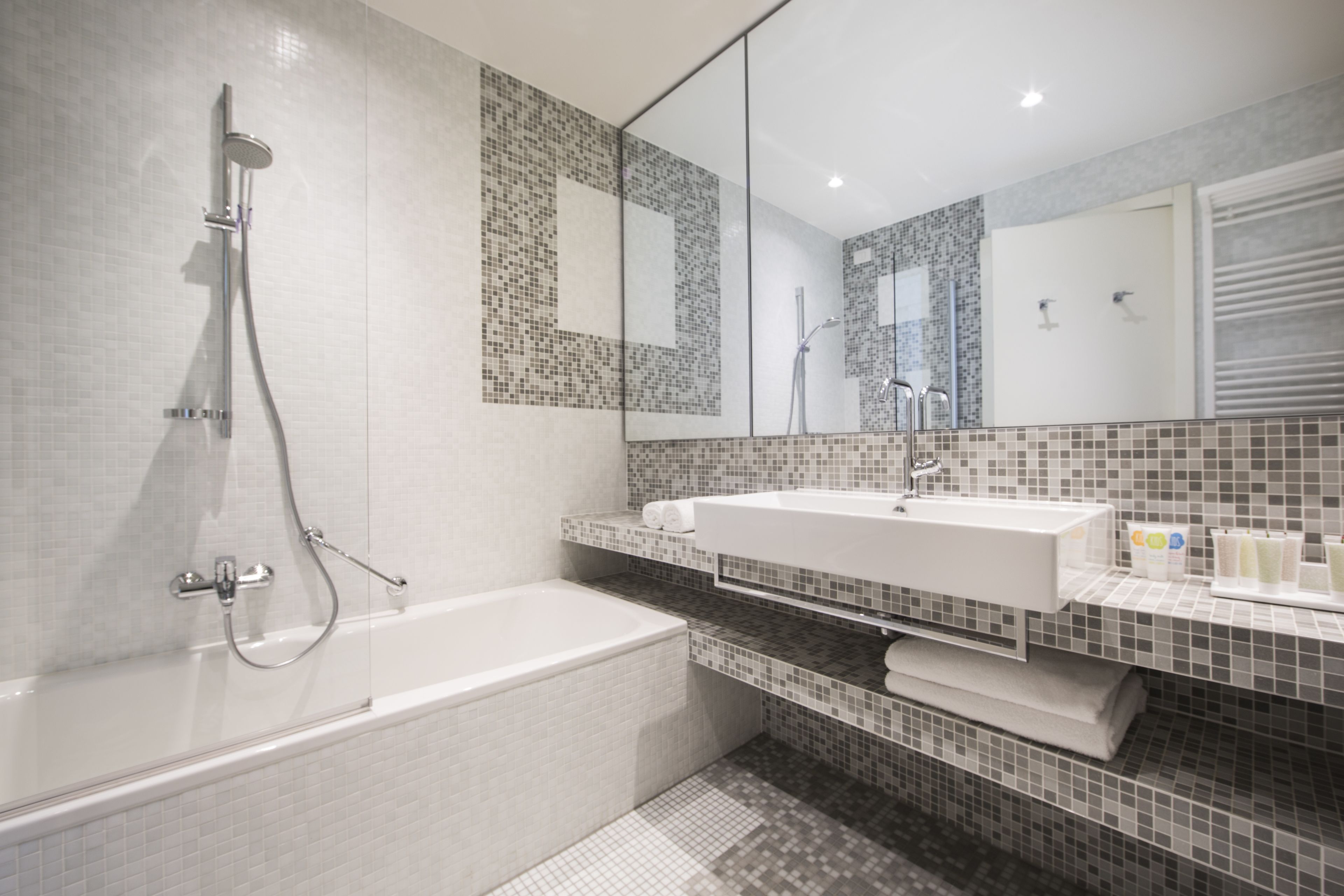 Une salle de bain moderne avec une grande baignoire, un lavabo et un espace douche.