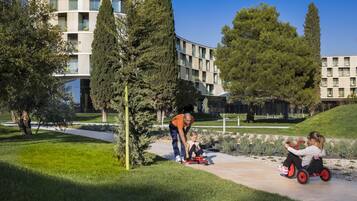 A modern building with a curved facade, surrounded by well-maintained grass and trees.