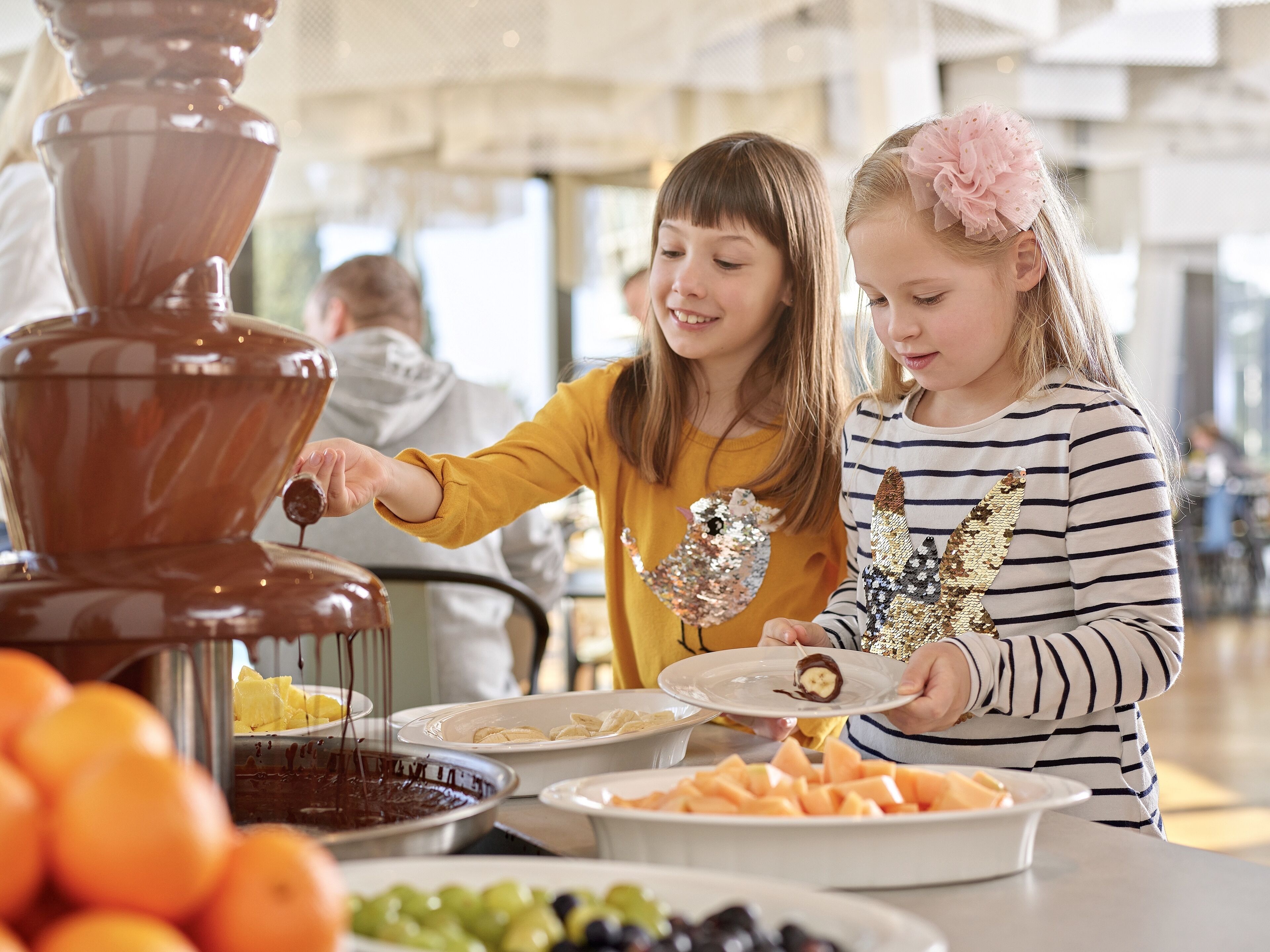 En buffé med ett varierat utbud av mat, inklusive frukt och en chokladfontän.