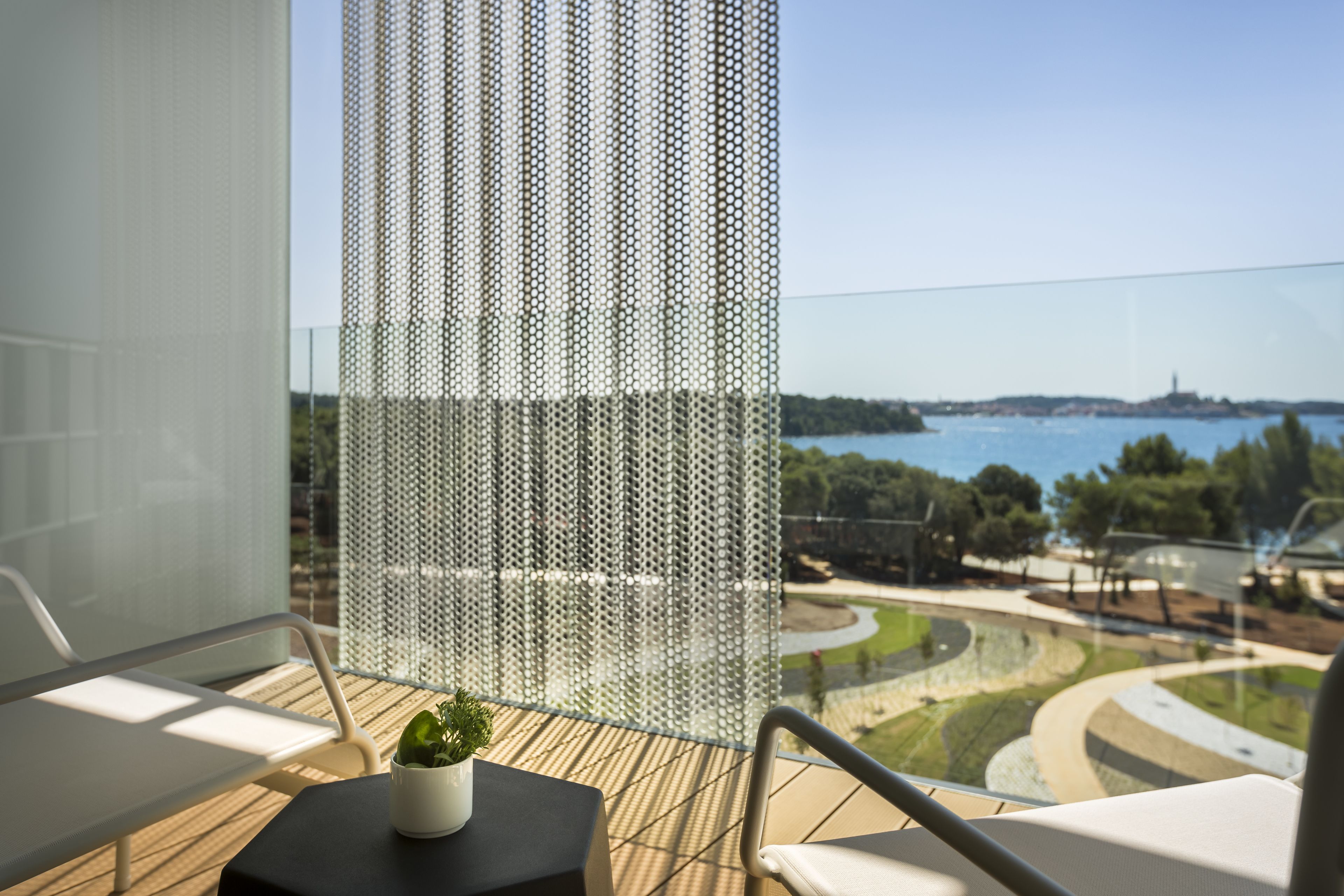 A balcony with a view of a body of water and a distant landscape.
