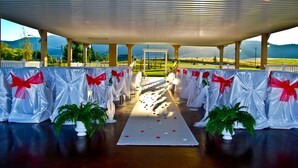 An aisle with white drapes and red bows, leading to a white archway. - Fairmont Hot Springs Resort (Anaconda)