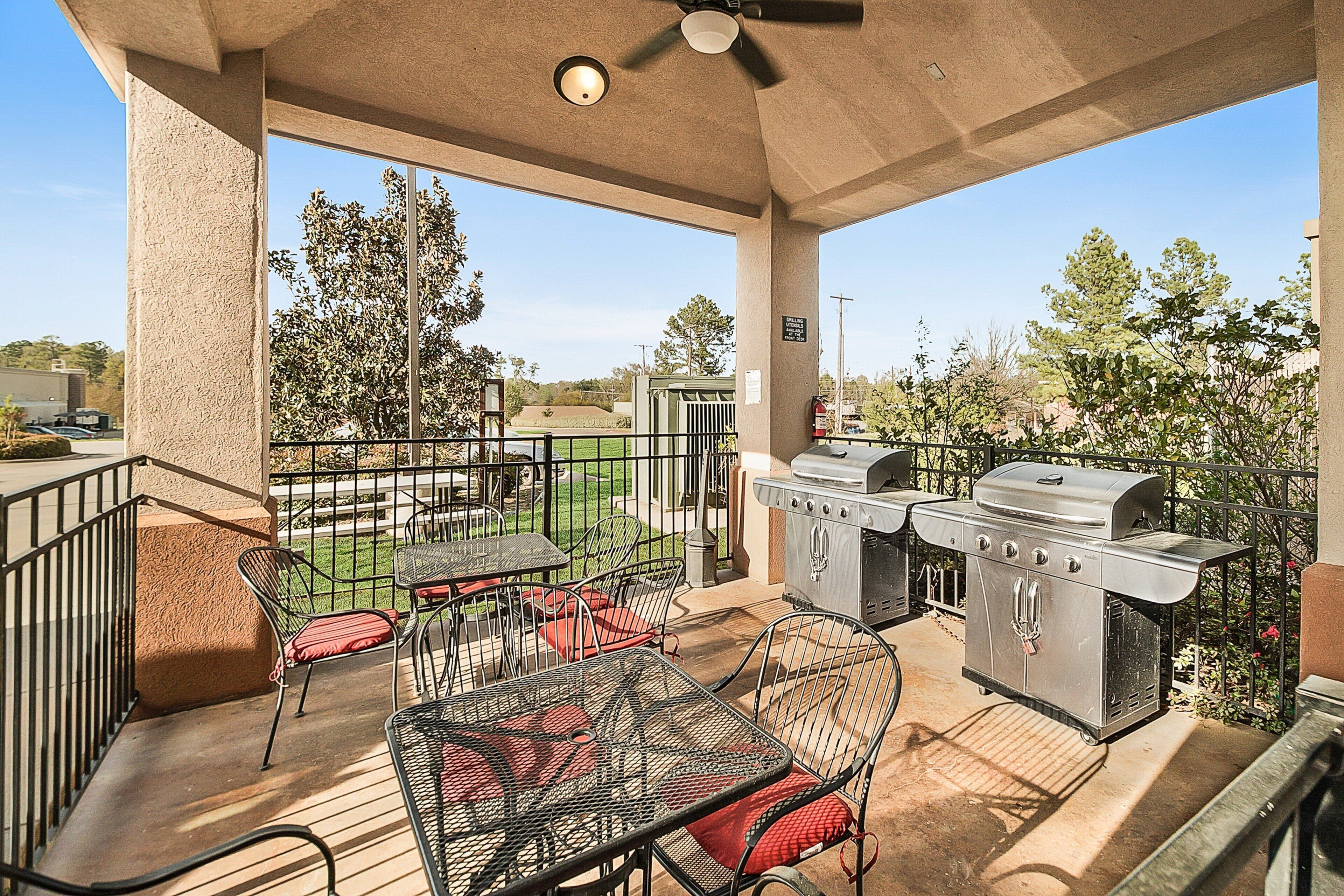 An outdoor patio with a grill and seating area.