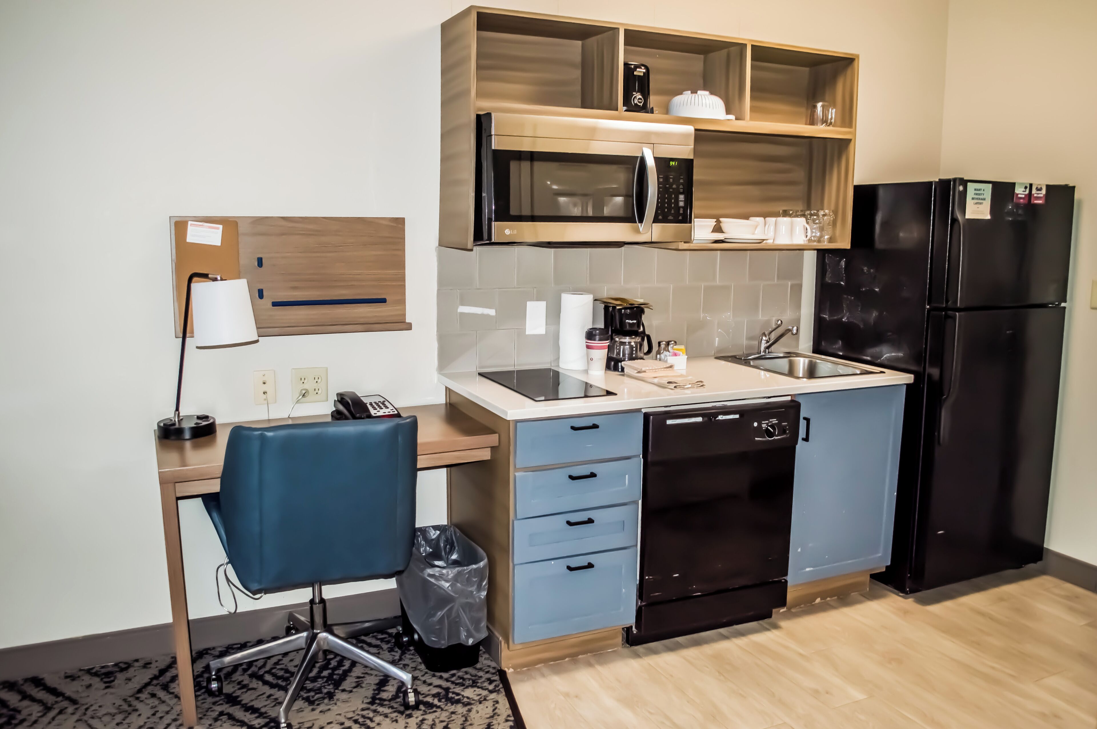 A compact kitchen with a microwave, refrigerator, and a small sink.