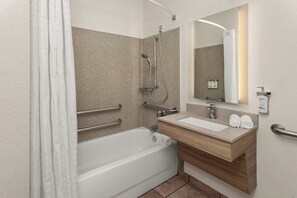 A modern bathroom with a bathtub, a sink, and a mirror. - Candlewood Suites Elgin by IHG (Elgin)