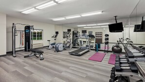 A gym with treadmills, weights, and exercise equipment.