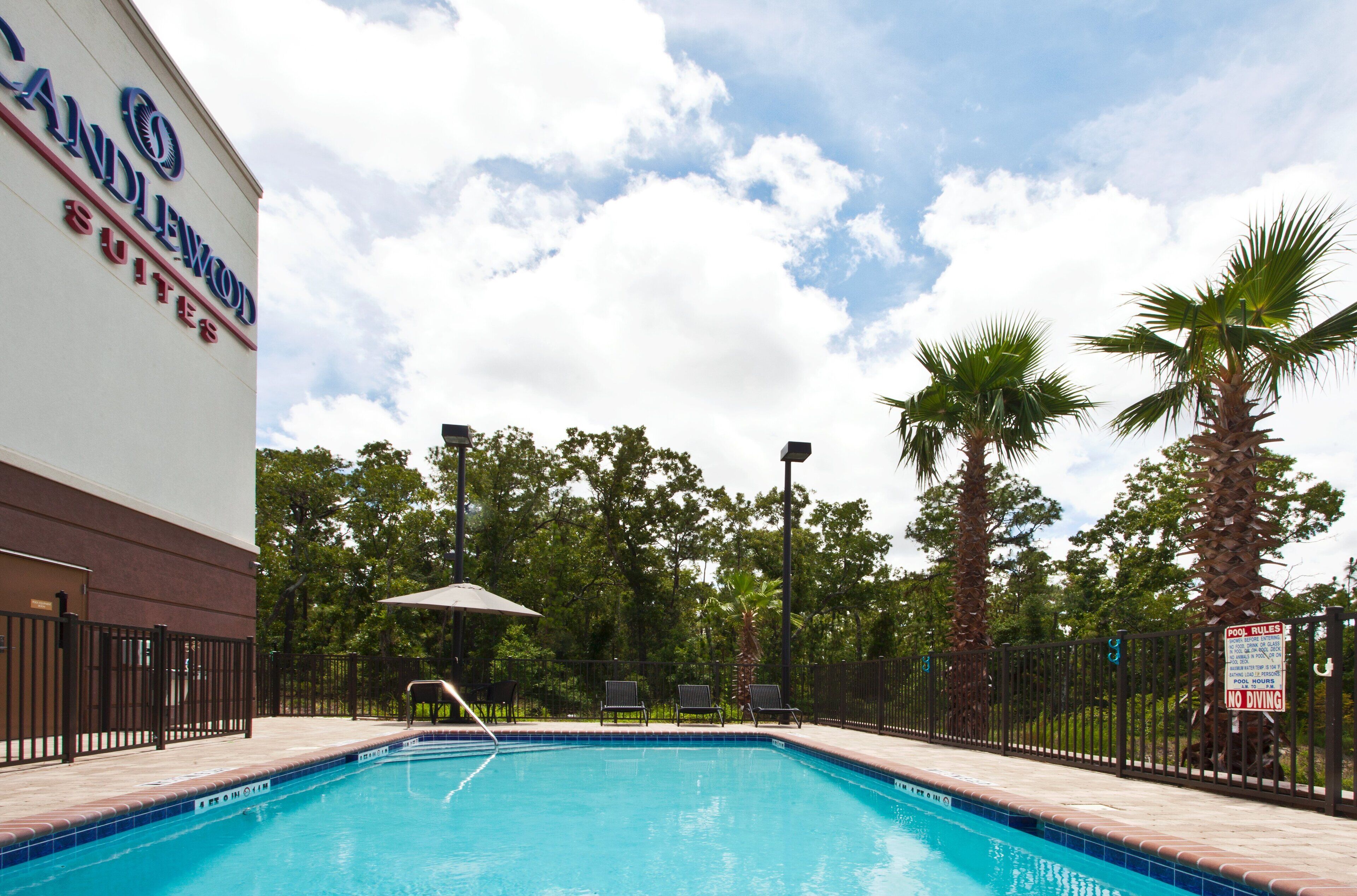 Area piscina di un hotel, con un cartello che indica 'Candlewood Suites'.