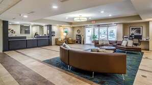 A spacious lobby with a reception desk, seating area, and a large window providing natural light. - Candlewood Suites Jacksonville East Merril Road by IHG (Jacksonville)