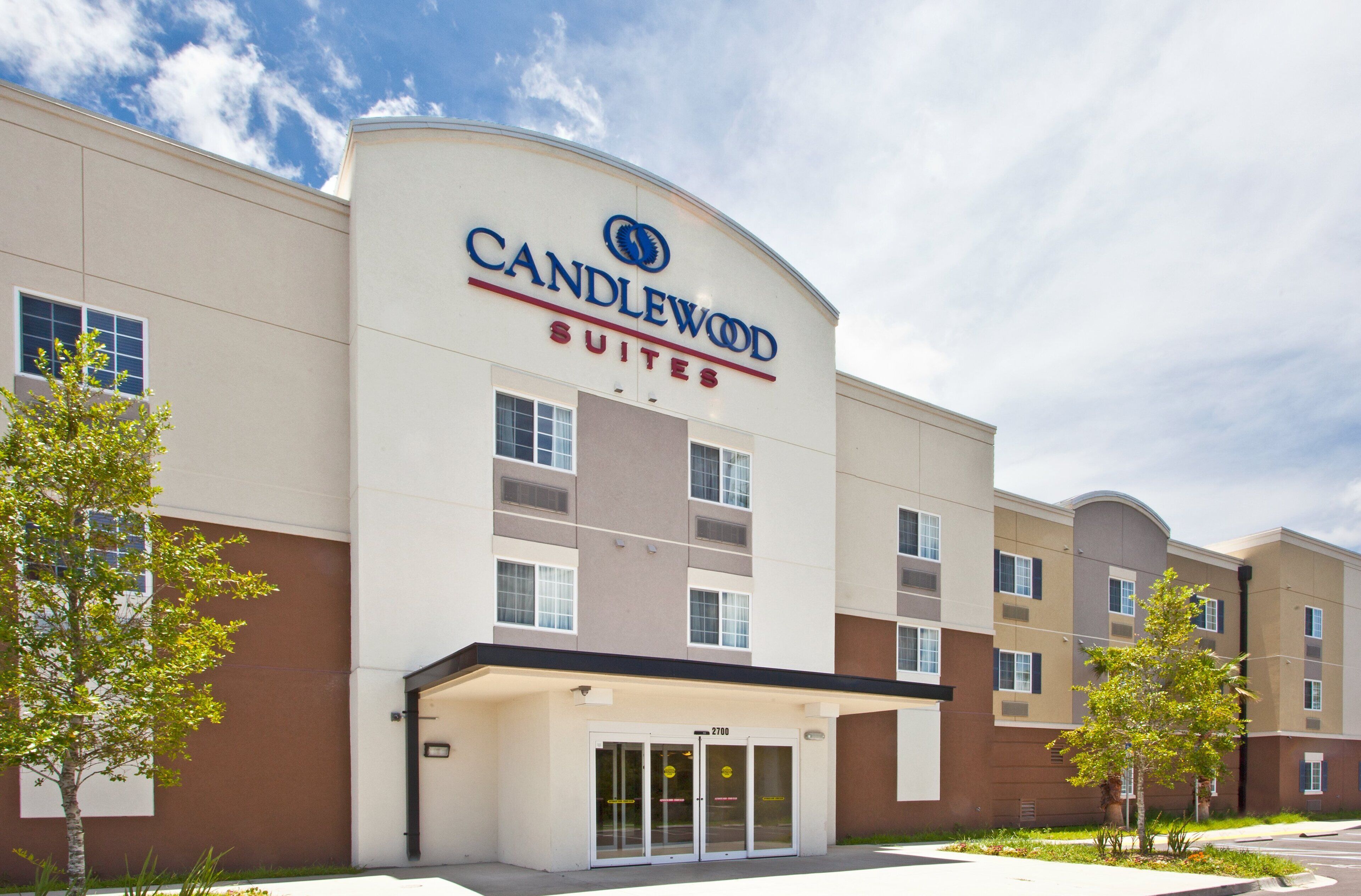 A hotel with a modern design, featuring a prominent "Candlewood Suites" sign.