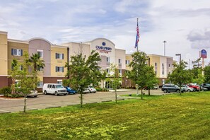 Stylish hotel with a flat roof and lush greenery, offering a convenient parking area.
